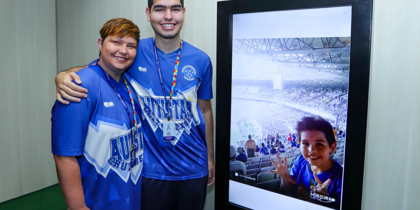 integrantes da torcida Autistas Cruzeirenses posam ao lado de foto que registra presença de um deles, quando criança, no mineirão