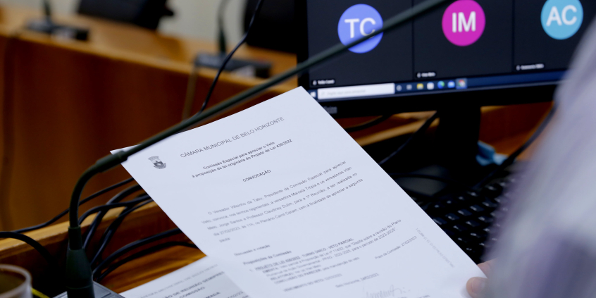 close nas mãos de parlamentar segurando pauta de reunião de comissão