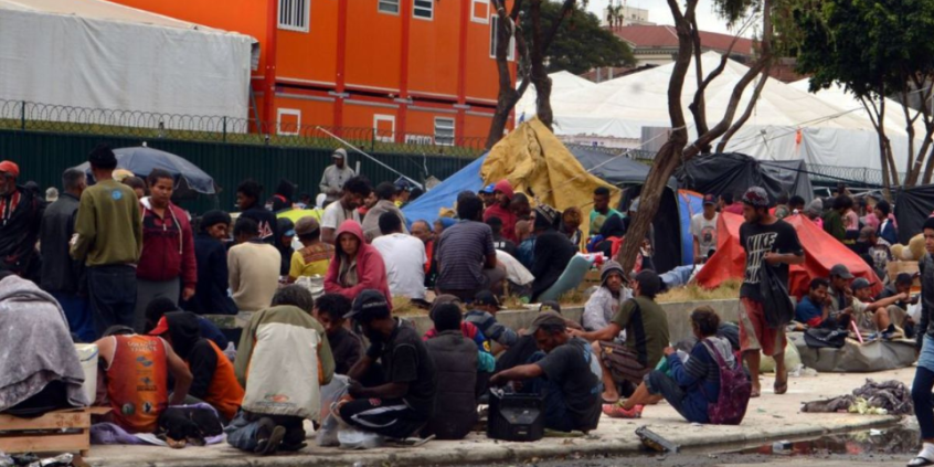 pessoas em situação de rua sentadas juntas e aglomeradas