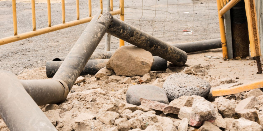 Canteiro de obras com pedras e canos retorcidos