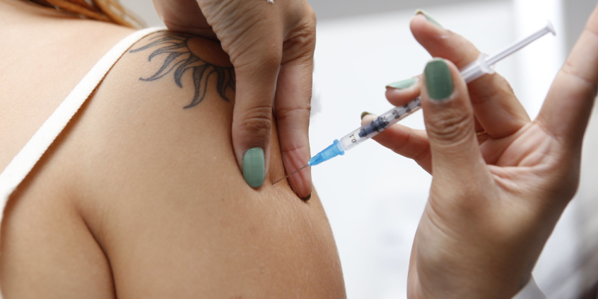 mulher recebendo vacina aplicada no braço