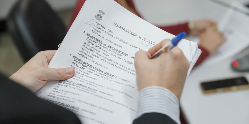 mãos de parlamentar segurando documentos