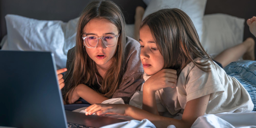 duas crianças em frente à tela de um computador