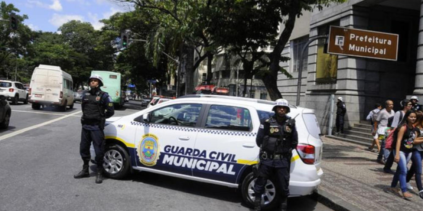 dois guardas civis ao lado de viatura