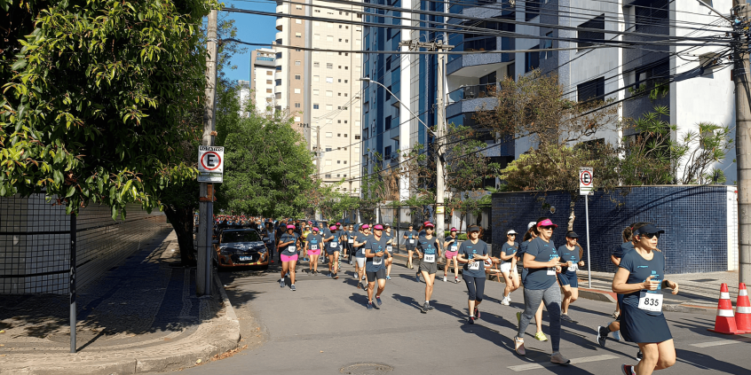 pessoas participam de corrida de rua em via pública