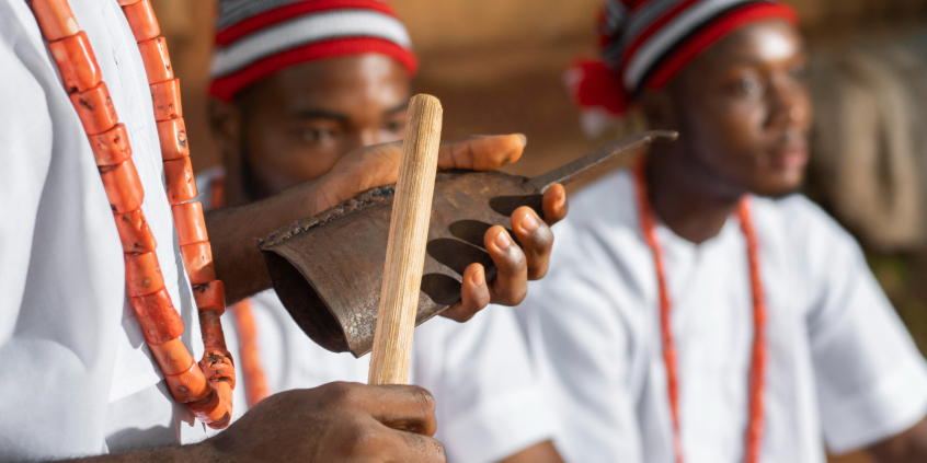 Instrumentos musicais em primeiro plano e pessoas com vestimentas afro
