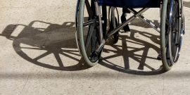 Imagem de uma cadeira de rodas, colocada de costas para o espectador