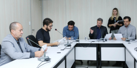 Os cinco integrantes da Comissão de Administração Pública sentados na Mesa do Plenário Helvécio Arantes apreciam a pauta da 18ª reunião ordinária