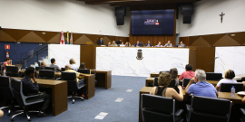 Parlamentares compõem mesa de reunião; convidados acompanham nas cadeiras do Plenário