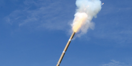 Detalhe de fogo de artifício aceso, com céu azul ao fundo