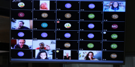 Cinco mulheres e dois homens conversam em conferência remota, dividinto suas imagens na tela de um computador. 