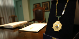 Medalha do GRande Colar do Mérito Legislativo em estojo, sob uma mesa