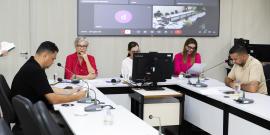 Imagem dos cinco integrantes da Comissão em torno de uma mesa em formato de U 