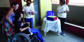 Pessoa em cadeira de rodas conversa com outras pessoas