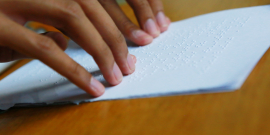 pessoa faz leitura de documento em braille