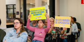 Participantes da audiência mostram cartazes com palavras de ordem
