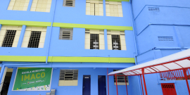 Fachada de escola pintada de azul e amarelo