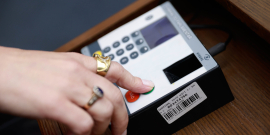 Mão pressiona equipamento eletrônico de votação na Câmara Municipal