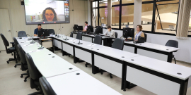 Vereador no Plenário Helvécio Arantes, com convidado aparecendo no telão ao fundo