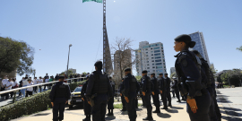 Guardas enfileirados em frente à bandeira do Brasil