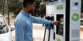 homem utiliza terminal de carga de veículo