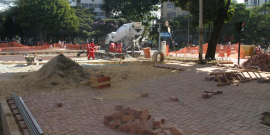 Homens trabalham em reforma de praça