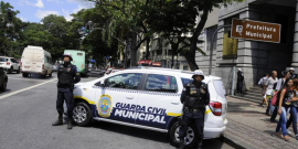 dois guardas civis ao lado de viatura