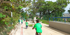 Crianças andam de bicicleta em área verde