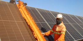 homem realiza instação de painel solar em teto