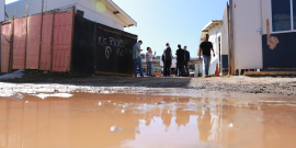 Rua do barreiro alagada e pessoas ao fundo durante visita técnica