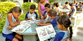 Estudantes em roda, supervisionados por profissional da Educação