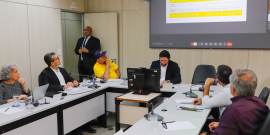 Participantes da audiência pública assentados no Plenário Helvécio Arantes. O telão mostra apresentação do relatório de prestação de contas