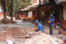 Trabalhadores realizam obra em via pública, em que retiram o calçamento original para intervir no subterrâneo.