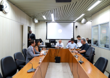 Cinco vereadores reunidos, sentados à mesa, em reunião.