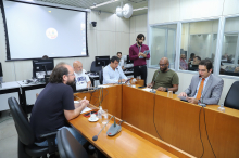 cinco vereadores reunidos, sentados à mesa, em reunião.