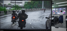Imagem da tela co computador com motos em cima de um viaduto. Ao fundo , o Plenário onde acontece a reunião