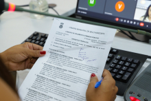 Imagem da pauta da reunião nas mãos de uma pessoa caucasiana