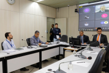 Imagem da reunião com os participantes sentados em volta da mesa em formato de U
