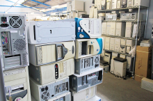 Foto de uma sala cheia de gabinetes de computadores antigos e empilhados.