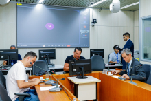 Vereadores discutem projetos no Plenário Camil Caram. O telão atrás deles mostra videochamada com vereadores presentes virtualmente.