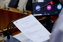 close nas mãos de parlamentar segurando pauta de reunião de comissão