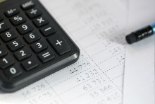 Calculadora sobre papel com lápis ao lado