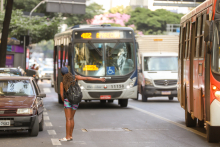 Mulher acena para ônibus parar em avenida de Belo Horizonte
