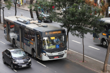 ônibus e automóvel trafegando em via pública